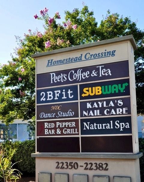 Monument sign listing all businesses in shopping center.